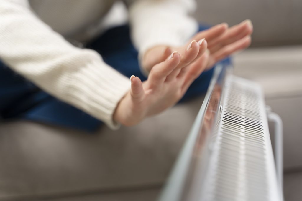 Close Up Hands Warming Up Near Heater Min