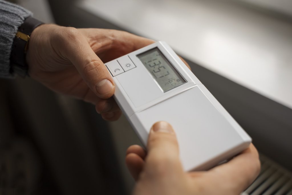 Man Turning Off Thermostat During Energy Crisis Min